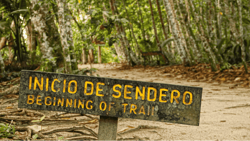 A hiking trail sign that reads in Spanish and English
